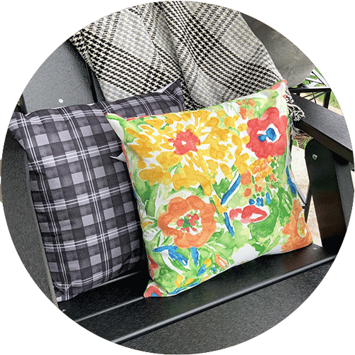 Two throw pillows, one with bright florals and one with black and white plaid.